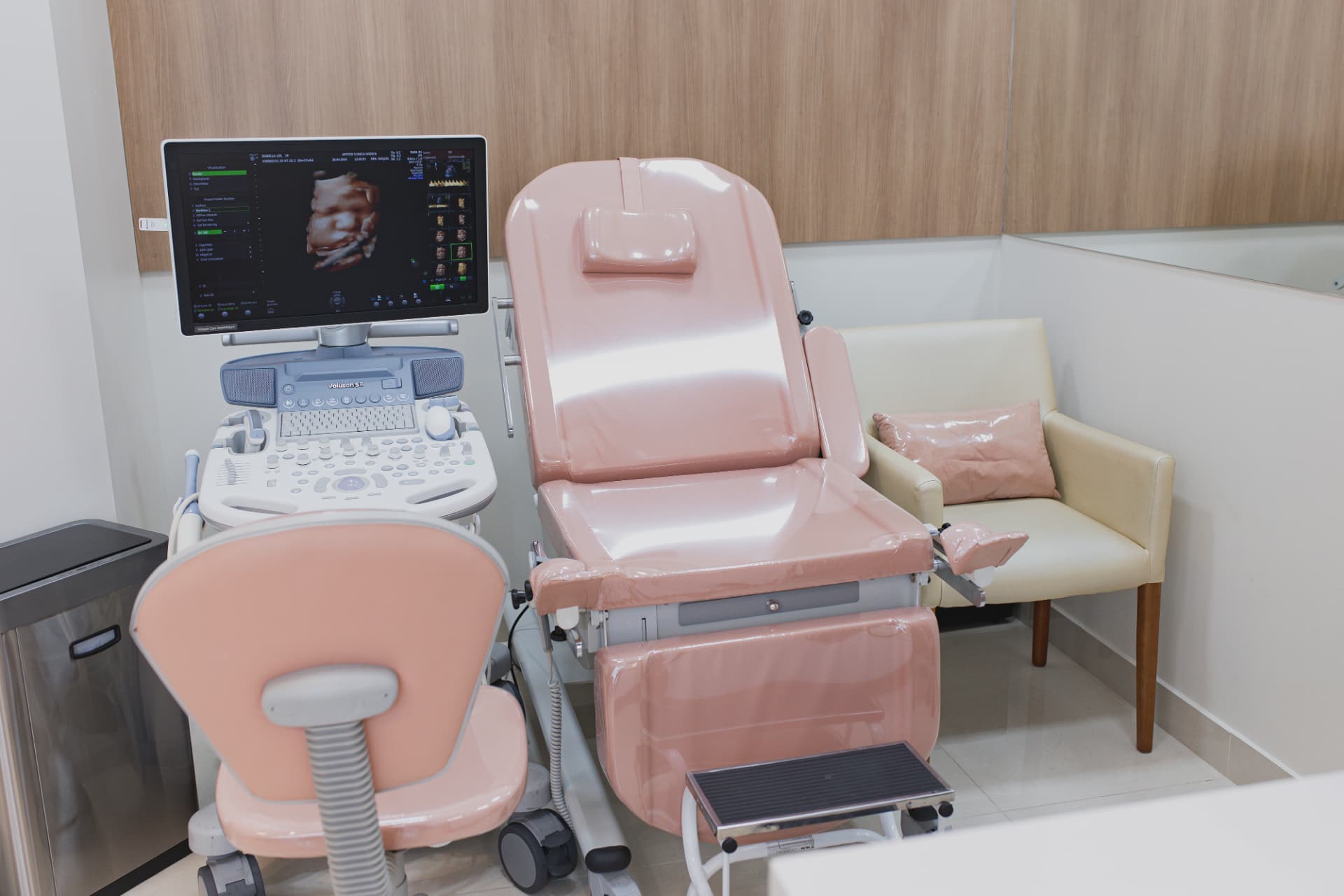 Sala de exames da Afetos Clínica Médica com maca rosa e ultrassom