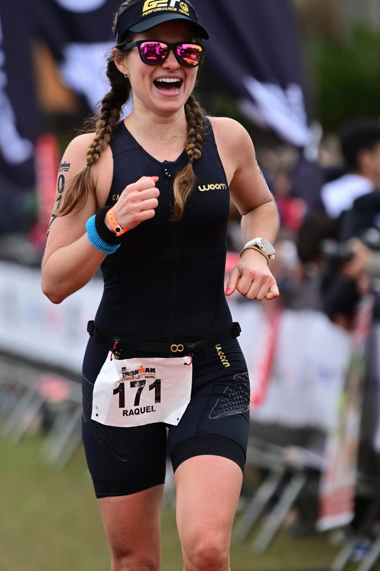 Dra. Raquel sorrindo ao cruzar a linha de chegada de um Ironman
